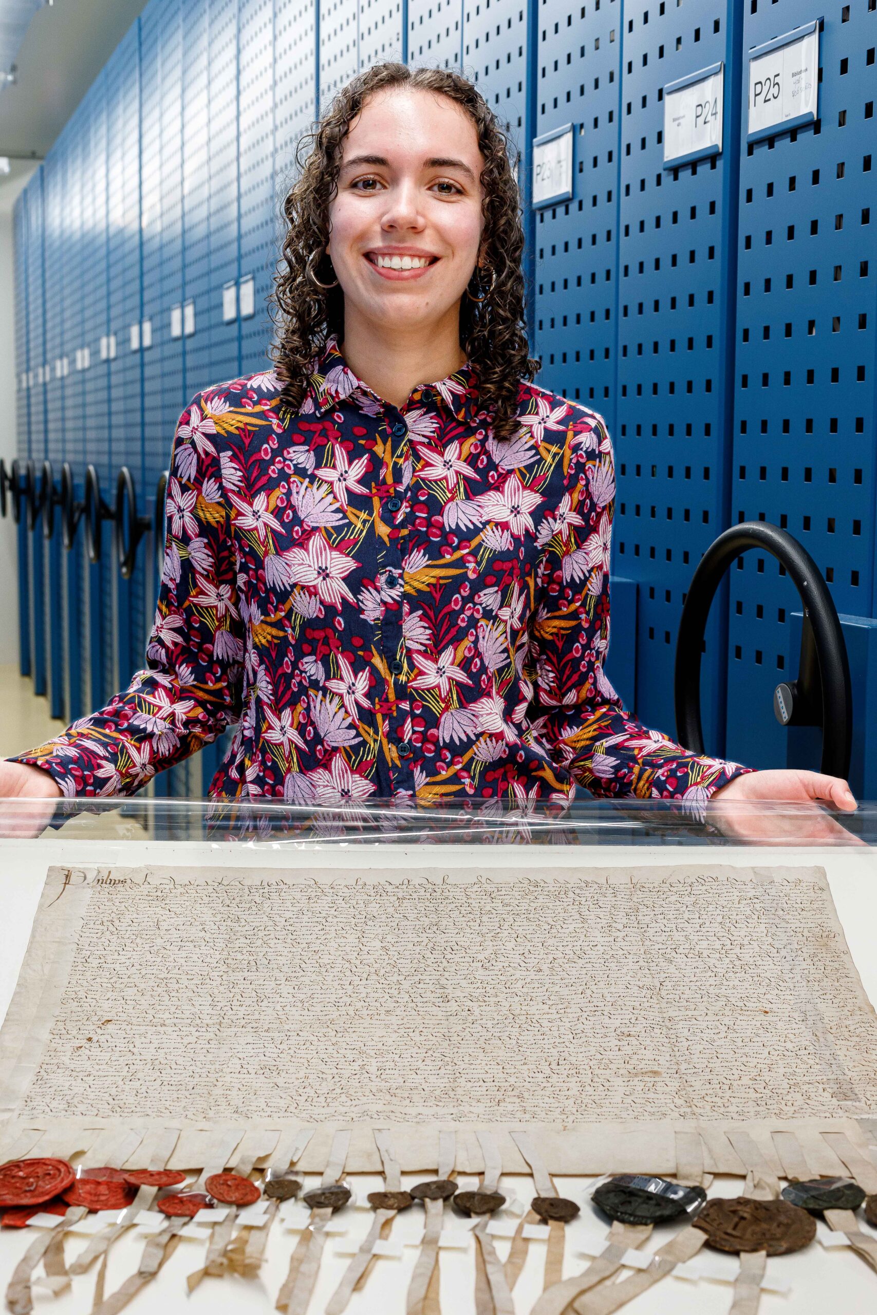 Femke Suurenbroek poserend met Akte van Verbond van de Bisschop van Utrecht uit 1519 (Archief 001, inventarisnummer 8). Foto door W. Leeman, 2024