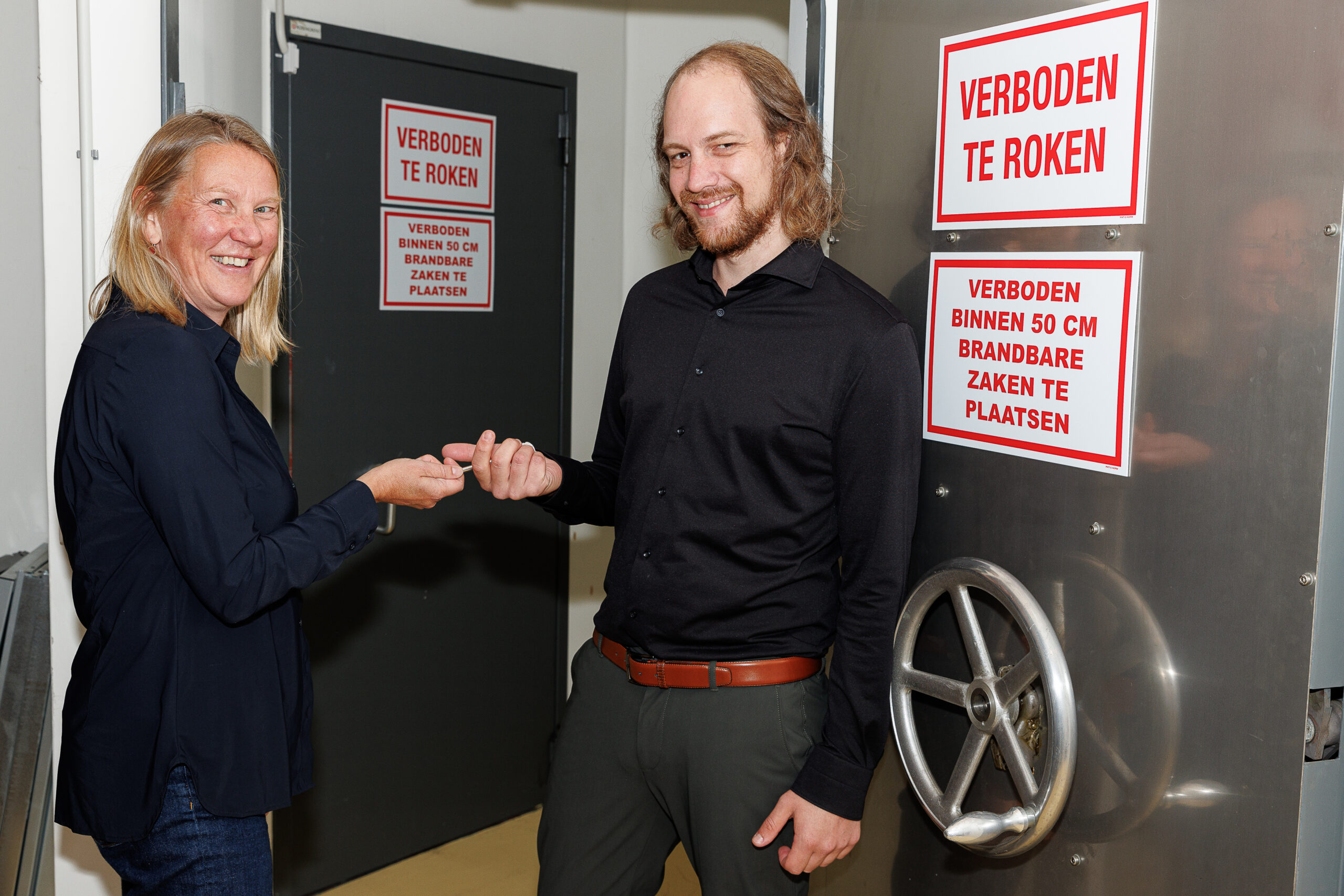 Foto van een symbolische sleuteloverdracht van Erika Hokke en Wietse Bakker voor de depotdeuren. Door Winfried Leeman, 2024